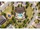 Aerial view of a community pool area with a pool, playground, lounge chairs, and lush landscaping in a circular setting at 8109 Ludington Cir, Orlando, FL 32836