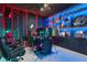 The gaming room showcases illuminated shelving and multi-screen setups, designed for immersive gaming sessions at 8109 Ludington Cir, Orlando, FL 32836