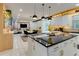 Modern kitchen with island, black countertops, white cabinets and stainless steel appliances at 8109 Ludington Cir, Orlando, FL 32836