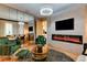 Elegant living room featuring a sleek fireplace, mirrored wall, modern lighting, and comfortable green armchairs at 8109 Ludington Cir, Orlando, FL 32836