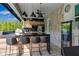 Outdoor bar with modern appliances and counter seating, perfect for entertaining by the pool at 8109 Ludington Cir, Orlando, FL 32836