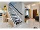 Modern staircase with glass railings, wooden steps, accent lighting, and elegant decor at 8109 Ludington Cir, Orlando, FL 32836