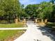 Long driveway with stone gate leading to a beautiful property surrounded by lush trees and well manicured lawn at 840 Dyson Dr, Winter Springs, FL 32708