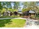Stunning exterior of log cabin style home with stone details, mature trees, and a welcoming front yard at 840 Dyson Dr, Winter Springs, FL 32708
