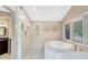 Enjoy this main bathroom, showcasing a garden tub, decorative tile, and shower with glass blocks at 840 Dyson Dr, Winter Springs, FL 32708