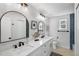 Bright bathroom featuring double vanity, modern fixtures, dual arched mirrors, and stylish decor at 1000 Farmstead St, Eustis, FL 32736