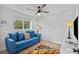 Cozy room with blue couch, fan, and colorful rug, perfect for relaxing or a home office at 1000 Farmstead St, Eustis, FL 32736