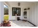 Charming front porch with a welcoming door, stylish lighting, and tasteful decorations at 1000 Farmstead St, Eustis, FL 32736