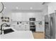 Modern kitchen with stainless steel appliances, quartz countertops, white cabinets, and hardwood floors at 1000 Farmstead St, Eustis, FL 32736