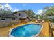 Backyard with pool, wooden deck, patio under pergola, and exterior of gray two-story home at 1010 Chokecherry Dr, Winter Springs, FL 32708