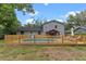 Backyard with gray home, pool, deck, wooden fence, shed, and covered patio at 1010 Chokecherry Dr, Winter Springs, FL 32708