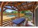 Backyard featuring a covered outdoor dining area, deck with pool access, and lush landscaping at 1010 Chokecherry Dr, Winter Springs, FL 32708