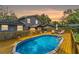 Backyard with pool, wooden deck, patio under pergola, and exterior of gray two-story home at 1010 Chokecherry Dr, Winter Springs, FL 32708