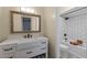 Bathroom with farmhouse sink, framed mirror, and a white tiled shower with black hardware at 1010 Chokecherry Dr, Winter Springs, FL 32708