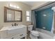 Well-lit bathroom featuring a farmhouse sink, framed mirror, and a shower with blue tiling at 1010 Chokecherry Dr, Winter Springs, FL 32708