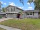 Attractive two-story home featuring gray siding, green lawn, and a brightly colored pink front door at 1010 Chokecherry Dr, Winter Springs, FL 32708