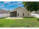 Green backyard featuring a screened-in patio, well-maintained lawn, and white privacy fence at 10621 Golden Cypress Ct, Orlando, FL 32836