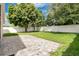 Large backyard featuring a paver patio, green grass, and a white privacy fence at 10621 Golden Cypress Ct, Orlando, FL 32836
