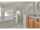 Bathroom featuring a soaking tub, glass shower, and granite countertops at 10621 Golden Cypress Ct, Orlando, FL 32836