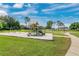 Community playground featuring swings and slides. Includes a basketball court and grassy areas for outdoor activities at 10621 Golden Cypress Ct, Orlando, FL 32836