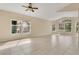 Expansive open-concept living space with tile flooring, a ceiling fan, and large windows for ample natural light at 10621 Golden Cypress Ct, Orlando, FL 32836