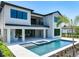 Rear exterior shot of a two-story house showcasing a large backyard with a pool and patio at 1080 E Jack Nicklaus Ct, Kissimmee, FL 34747