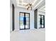 Bright foyer features tile floors, modern light fixture, and mirrors adding depth to the space at 1080 E Jack Nicklaus Ct, Kissimmee, FL 34747