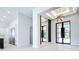A modern foyer with sleek tile flooring, a view of the kitchen, large mirrors, and decorative wall panels at 1080 E Jack Nicklaus Ct, Kissimmee, FL 34747