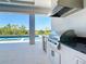 Close up of the outdoor kitchen with stainless steel appliances and black countertops at 1080 E Jack Nicklaus Ct, Kissimmee, FL 34747