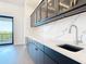 Elegant wet bar with granite countertops, custom cabinetry, and stainless steel sink at 1080 E Jack Nicklaus Ct, Kissimmee, FL 34747