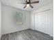 Bright bedroom with wood-look floors, ceiling fan, and large closet at 12388 Se 106Th Ave, Belleview, FL 34420