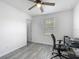 Neutral bedroom showcasing wood-look floors, ceiling fan, and well-lit window at 12388 Se 106Th Ave, Belleview, FL 34420