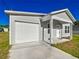 Well-maintained home with an attached garage, a neatly paved driveway, and freshly cut green grass at 12388 Se 106Th Ave, Belleview, FL 34420
