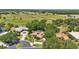 Aerial view of a home showcases mature landscaping and screened-in pool amidst lush green trees in the community at 128 Lake Region Cir, Winter Haven, FL 33881