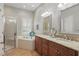 Bathroom with walk-in shower, soaking tub, double vanity with granite countertop, and natural light at 128 Lake Region Cir, Winter Haven, FL 33881