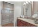 Bathroom with granite-topped vanity, framed mirror, and shower over tub with sliding glass door at 128 Lake Region Cir, Winter Haven, FL 33881