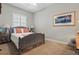 This bedroom offers neutral carpet and paint, large window and decorative artwork at 128 Lake Region Cir, Winter Haven, FL 33881