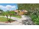 Charming single-story home features a well-manicured lawn, mature landscaping, and a circular driveway at 128 Lake Region Cir, Winter Haven, FL 33881