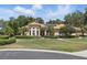 Inviting home with manicured lawn, arched windows, tile roof, and lush landscaping creates great curb appeal at 128 Lake Region Cir, Winter Haven, FL 33881