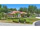 Inviting home with manicured lawn, arched windows, tile roof, and lush landscaping creates great curb appeal at 128 Lake Region Cir, Winter Haven, FL 33881