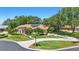 Inviting home with manicured lawn, arched windows, tile roof, and lush landscaping creates great curb appeal at 128 Lake Region Cir, Winter Haven, FL 33881