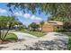 Charming single-story home features a well-manicured lawn, mature landscaping, and a circular driveway at 128 Lake Region Cir, Winter Haven, FL 33881