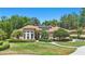 Charming home featuring a beautiful lawn, lush landscaping, and solar panels on the roof at 128 Lake Region Cir, Winter Haven, FL 33881