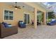 Screened lanai includes ceiling fans, comfortable lounge seating, and dining area at 128 Lake Region Cir, Winter Haven, FL 33881