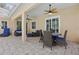 Outdoor living space includes ceiling fans, comfortable lounge chairs, and dining area at 128 Lake Region Cir, Winter Haven, FL 33881