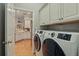 Laundry room with tile floor, storage cabinets and modern washer and dryer at 128 Lake Region Cir, Winter Haven, FL 33881