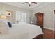 Primary bedroom featuring tray ceiling, wood floor, and shutters on the window at 128 Lake Region Cir, Winter Haven, FL 33881