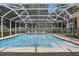 The beautiful screened pool features a water feature and brick paver patio at 128 Lake Region Cir, Winter Haven, FL 33881
