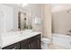Modern bathroom with a dark wood vanity, granite countertop, and tiled shower-tub combo at 1302 Nestled Valley Rd, Minneola, FL 34715
