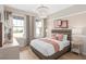 Stylishly decorated bedroom with a large window, plush bedding, and modern chandelier at 1302 Nestled Valley Rd, Minneola, FL 34715